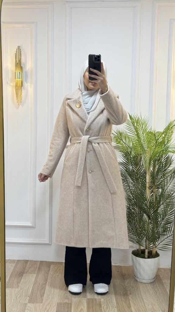 Elegant long coat with a tie at the waist and simple decorative touches perfect for winter looks Model G1560 Ecru